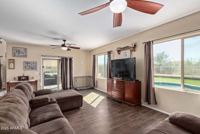 living area featuring dark wood-style floors, a ceiling fan, and baseboards