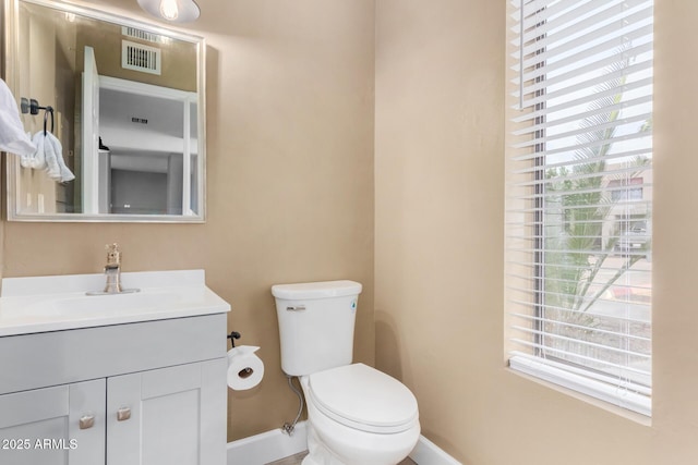 bathroom with visible vents, plenty of natural light, vanity, and toilet