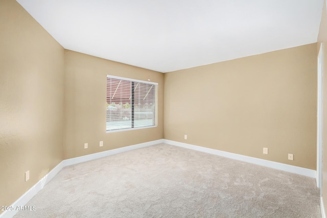 carpeted empty room featuring baseboards