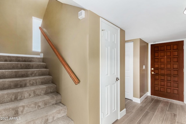 stairs featuring wood finished floors and baseboards