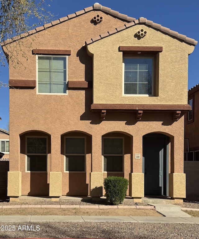 view of front of home featuring stucco siding and a tiled roof