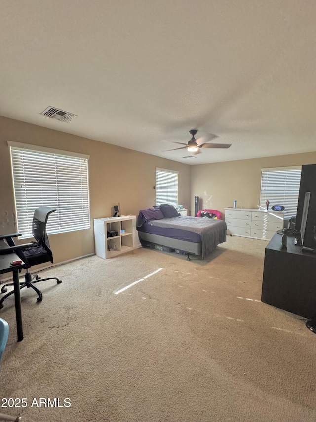 bedroom with carpet flooring, visible vents, and ceiling fan