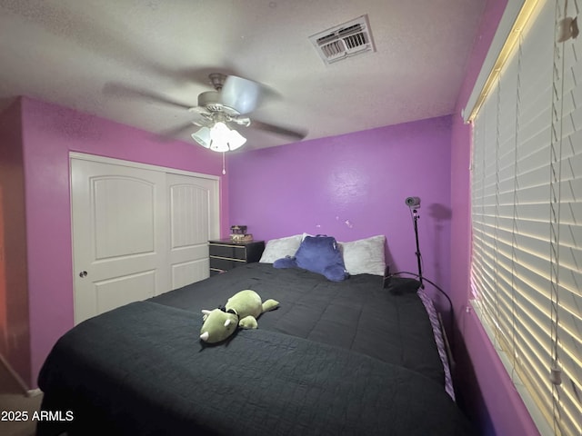 bedroom featuring a ceiling fan, visible vents, and a closet