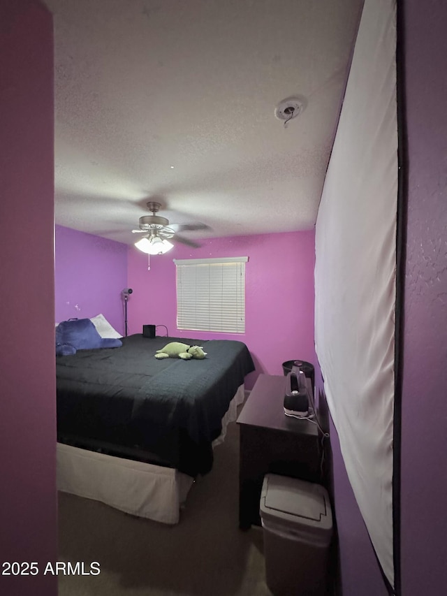 bedroom with a ceiling fan and a textured ceiling