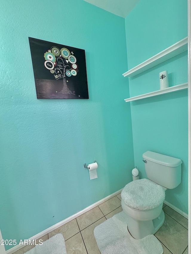 bathroom with tile patterned flooring, toilet, and baseboards