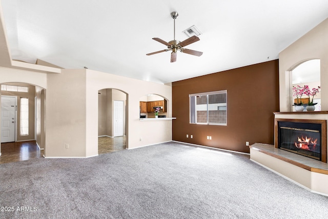 450 E Duke Dr, Casa Grande, AZ 85122 - unfurnished living room with carpet flooring, a ceiling fan, visible vents, arched walkways, and lofted ceiling