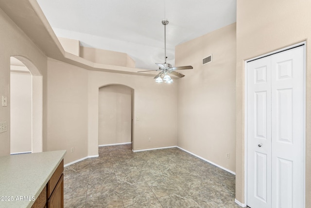 450 E Duke Dr, Casa Grande, AZ 85122 - interior space with arched walkways, stone finish flooring, ceiling fan, baseboards, and visible vents