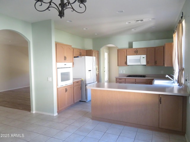 kitchen featuring light tile patterned flooring, sink, a notable chandelier, and white appliances