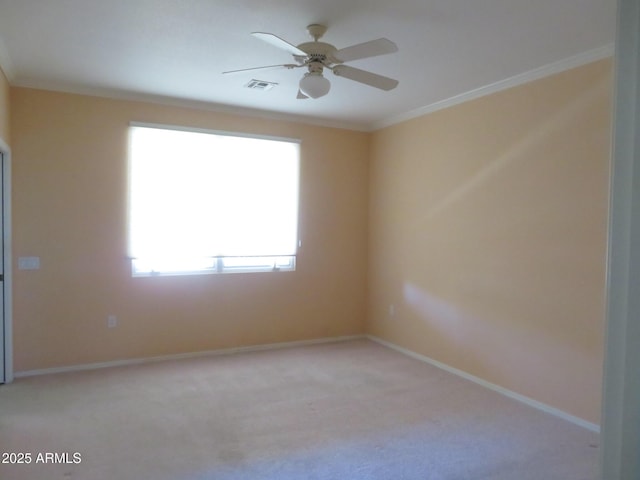 empty room featuring ornamental molding, light carpet, and ceiling fan