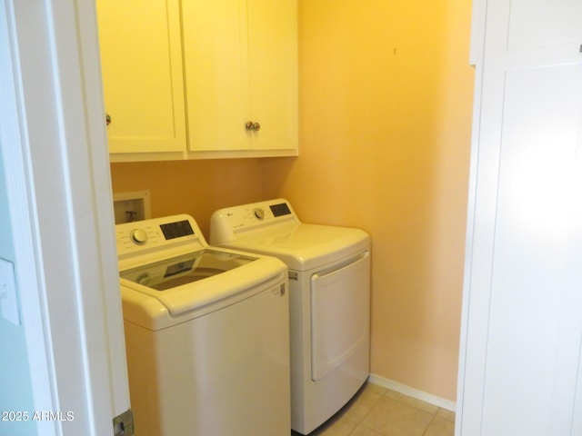 laundry room featuring light tile patterned flooring, cabinets, and separate washer and dryer