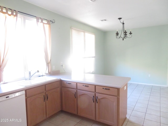 kitchen featuring light tile patterned floors, sink, dishwasher, decorative light fixtures, and kitchen peninsula