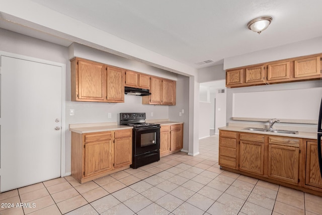 kitchen featuring sink, black electric range oven, and light tile patterned floors