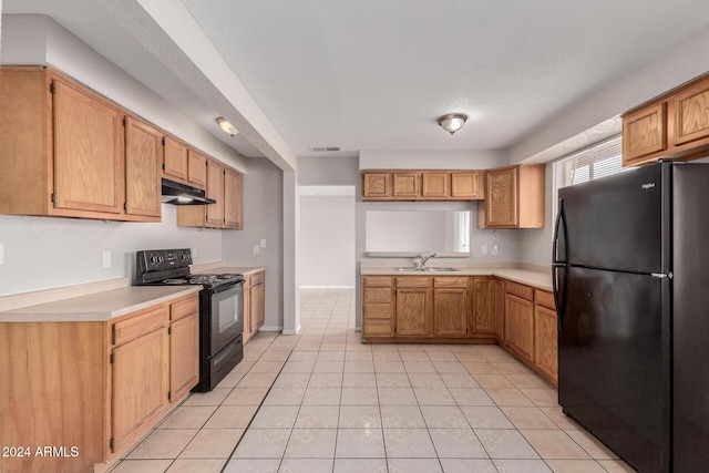 kitchen featuring sink, light tile patterned flooring, and black appliances