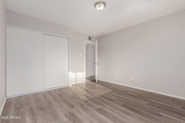 unfurnished bedroom featuring a closet and hardwood / wood-style flooring