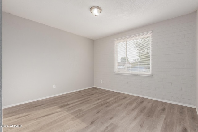 empty room featuring light hardwood / wood-style floors and a textured ceiling