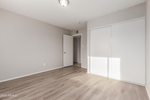 unfurnished bedroom with a closet and light hardwood / wood-style flooring