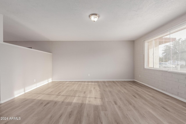 empty room featuring light hardwood / wood-style floors and a textured ceiling