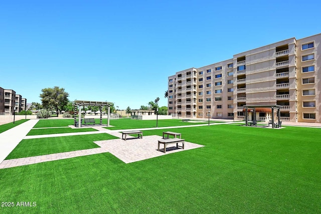 surrounding community with a lawn and a pergola