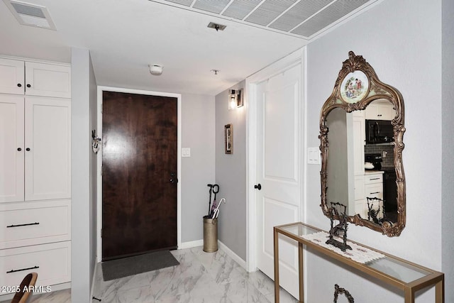 foyer with baseboards, visible vents, and marble finish floor