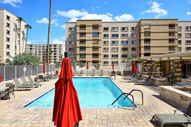 pool with a patio and fence