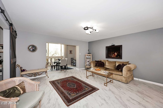 living area with baseboards, a barn door, and marble finish floor