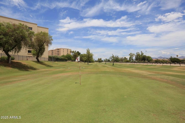 view of community featuring fence and view of golf course