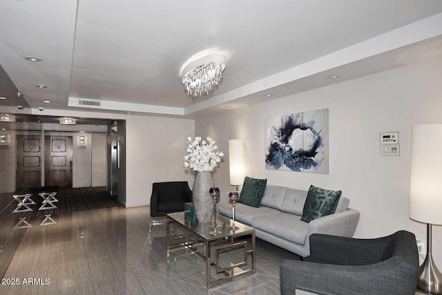 living area with visible vents, a tray ceiling, wood-type flooring, an inviting chandelier, and recessed lighting