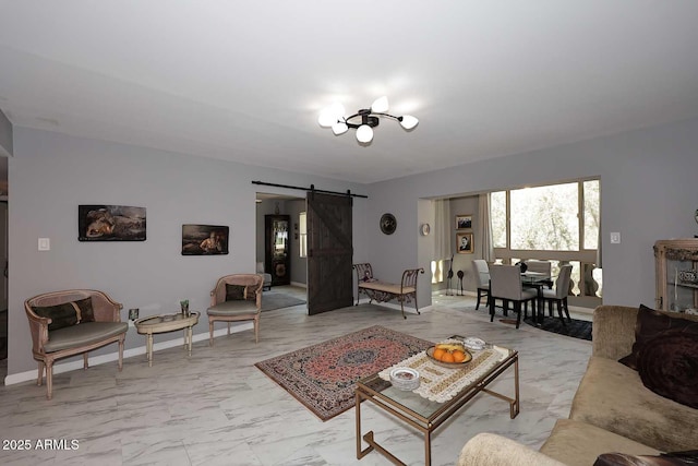 living room featuring baseboards, a barn door, and marble finish floor
