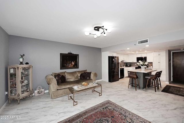 living area with baseboards, visible vents, recessed lighting, and marble finish floor