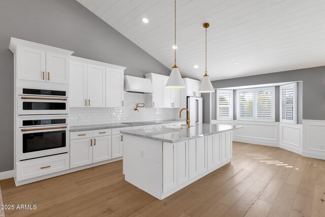 9136 N 81st St, Scottsdale, AZ 85258 - kitchen featuring light stone counters, custom range hood, and white cabinets