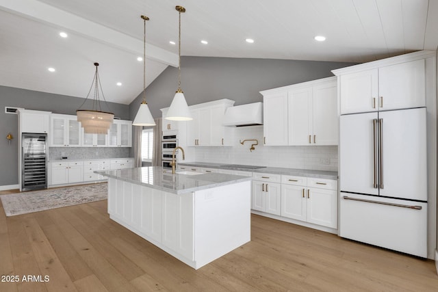 9136 N 81st St, Scottsdale, AZ 85258 - kitchen with built in fridge, white cabinetry, an island with sink, custom exhaust hood, and beverage cooler