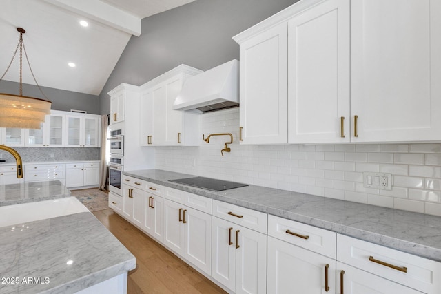 9136 N 81st St, Scottsdale, AZ 85258 - kitchen with white cabinetry, black electric cooktop, light stone counters, and custom range hood