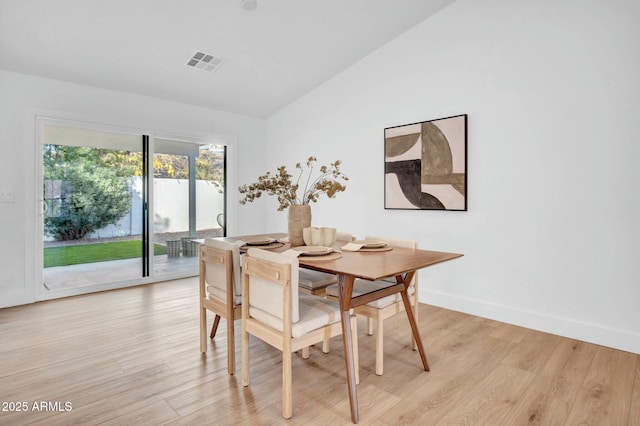 dining space with lofted ceiling and light hardwood / wood-style floors