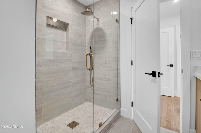 bathroom with an enclosed shower and tile patterned flooring