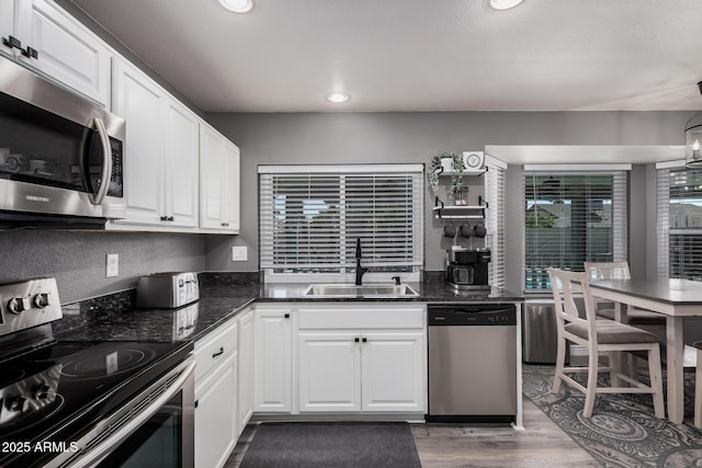 kitchen with a sink, white cabinets, and stainless steel appliances