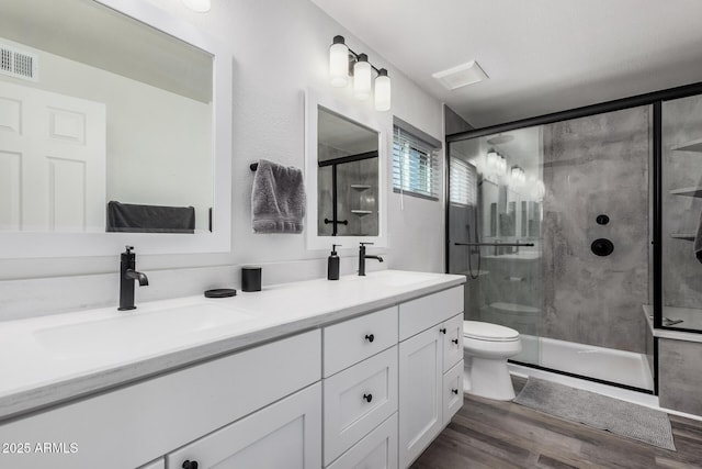 full bathroom featuring a sink, visible vents, wood finished floors, and double vanity