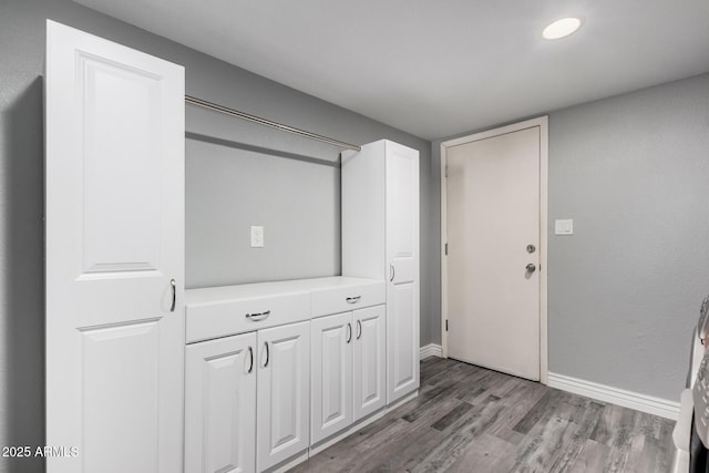 interior space featuring baseboards and wood finished floors