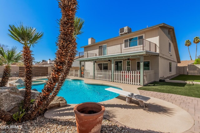 rear view of house with a fenced backyard, a patio area, a ceiling fan, and a balcony