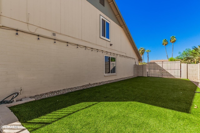 view of home's exterior with a yard and a fenced backyard