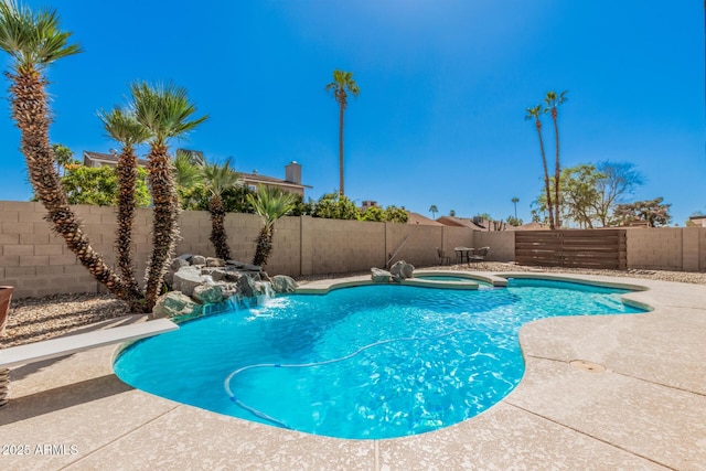 view of swimming pool featuring a patio area, a fenced backyard, and a pool with connected hot tub