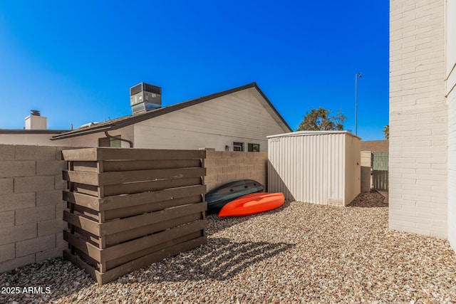 view of yard featuring an outdoor structure, central air condition unit, fence, and a shed