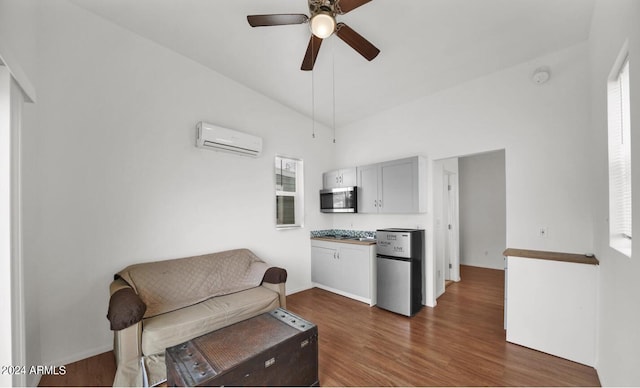 sitting room featuring dark wood-type flooring, vaulted ceiling, a wall unit AC, and ceiling fan