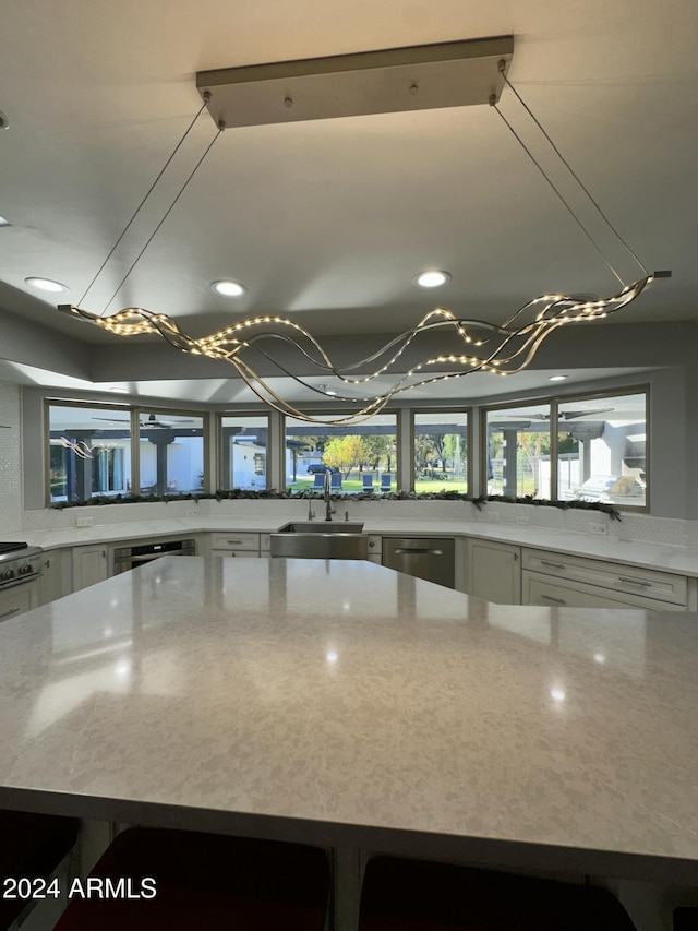 2311 E Colter St, Phoenix, AZ 85016 - kitchen featuring a sink, a chandelier, stainless steel appliances, white cabinetry, and light stone countertops