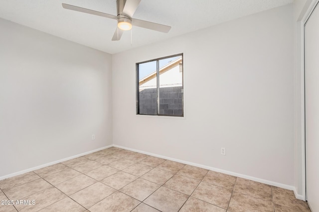 empty room with light tile patterned floors, ceiling fan, and baseboards