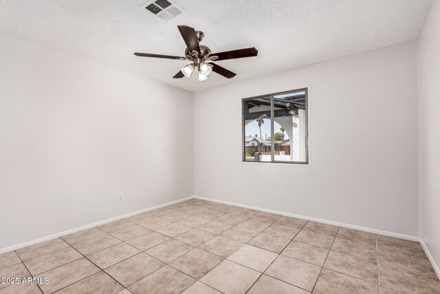 unfurnished room with a textured ceiling, a ceiling fan, light tile patterned floors, and baseboards