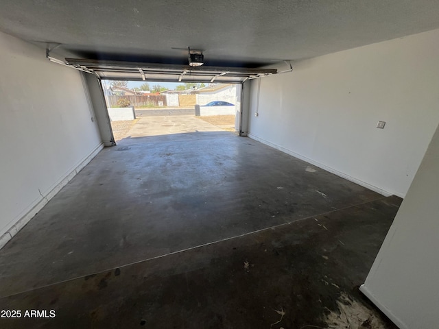 garage with a garage door opener and baseboards
