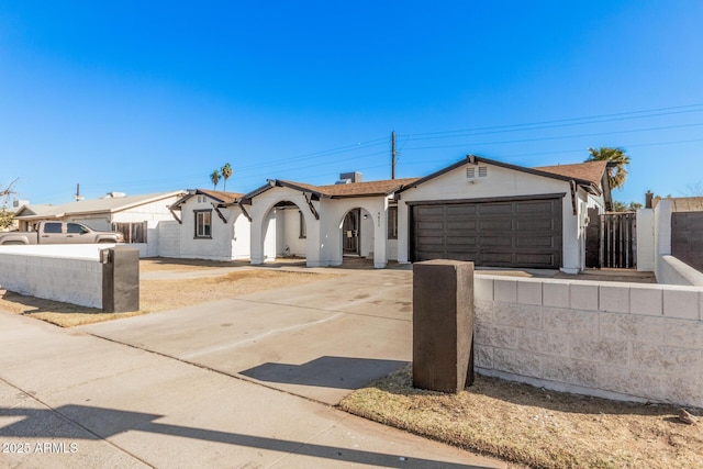 ranch-style home with driveway, fence, and an attached garage