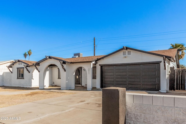 ranch-style house with driveway, a garage, stucco siding, and fence