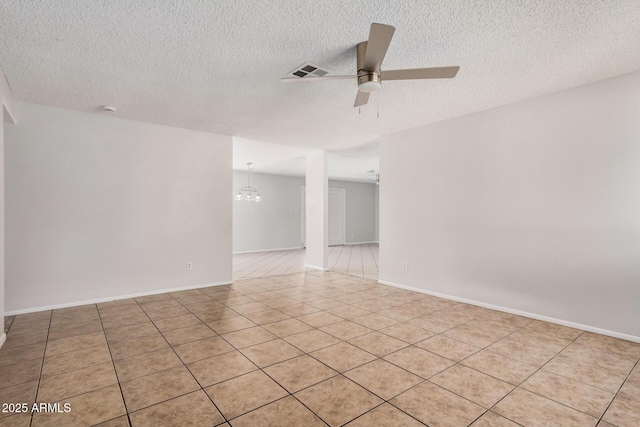 empty room featuring ceiling fan, a textured ceiling, a chandelier, and light tile patterned floors