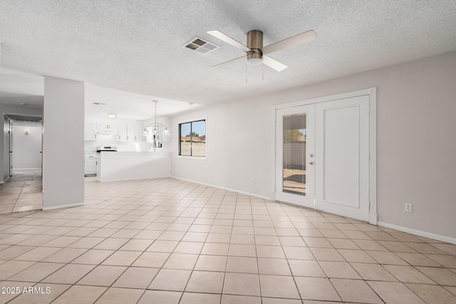unfurnished living room featuring a ceiling fan, a textured ceiling, baseboards, and light tile patterned floors